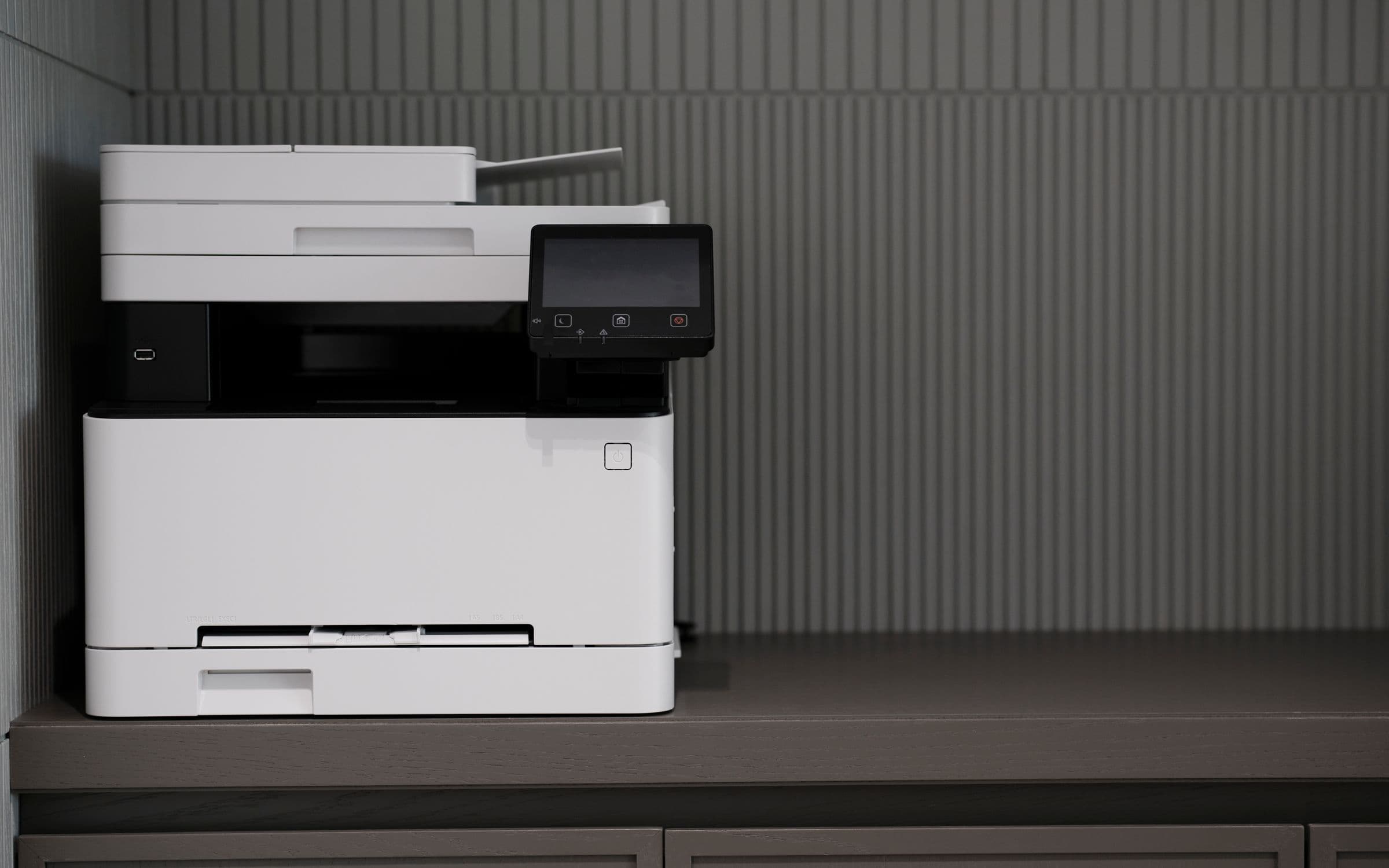 A modern white office multifunction printer in a clean, minimalist workspace