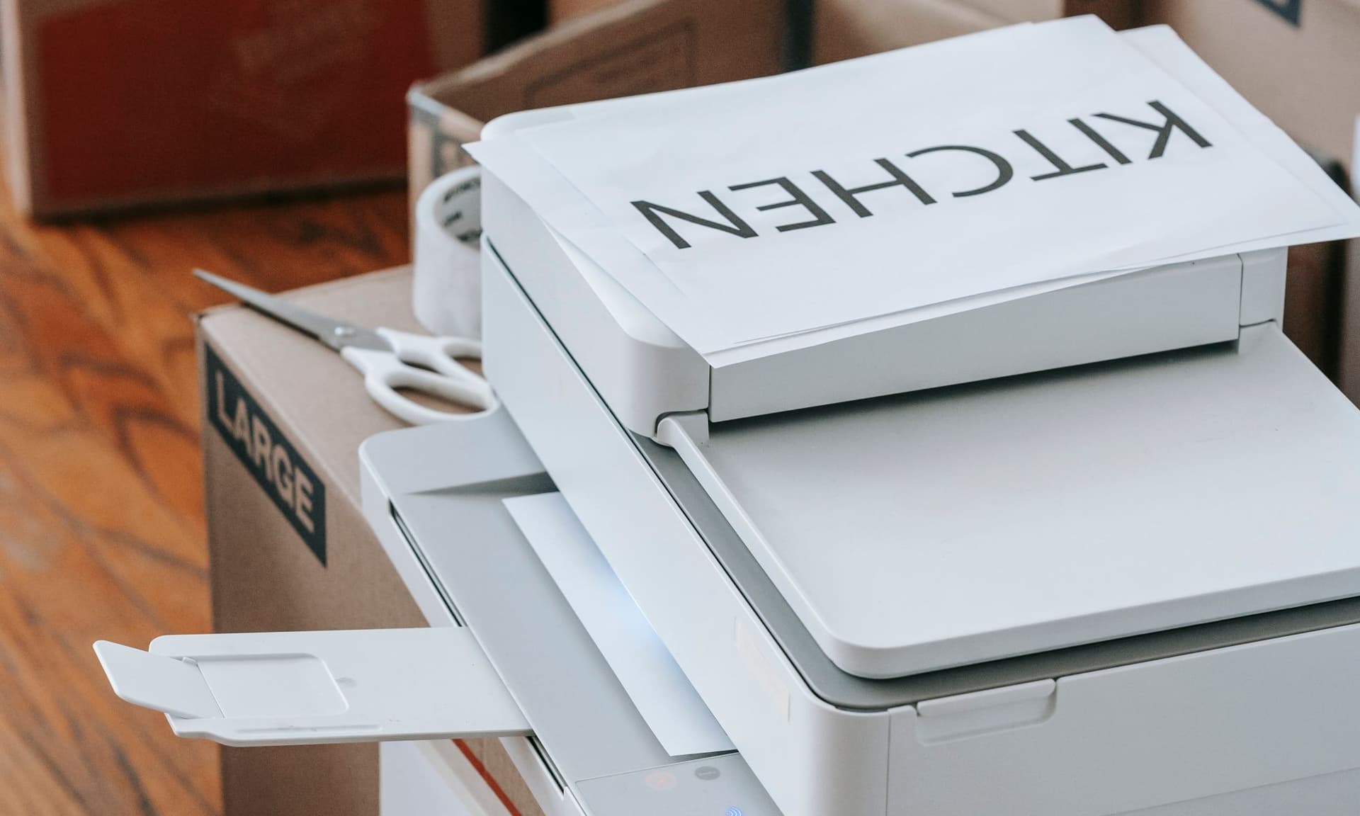 An office printer with documents and packing boxes ready to go out